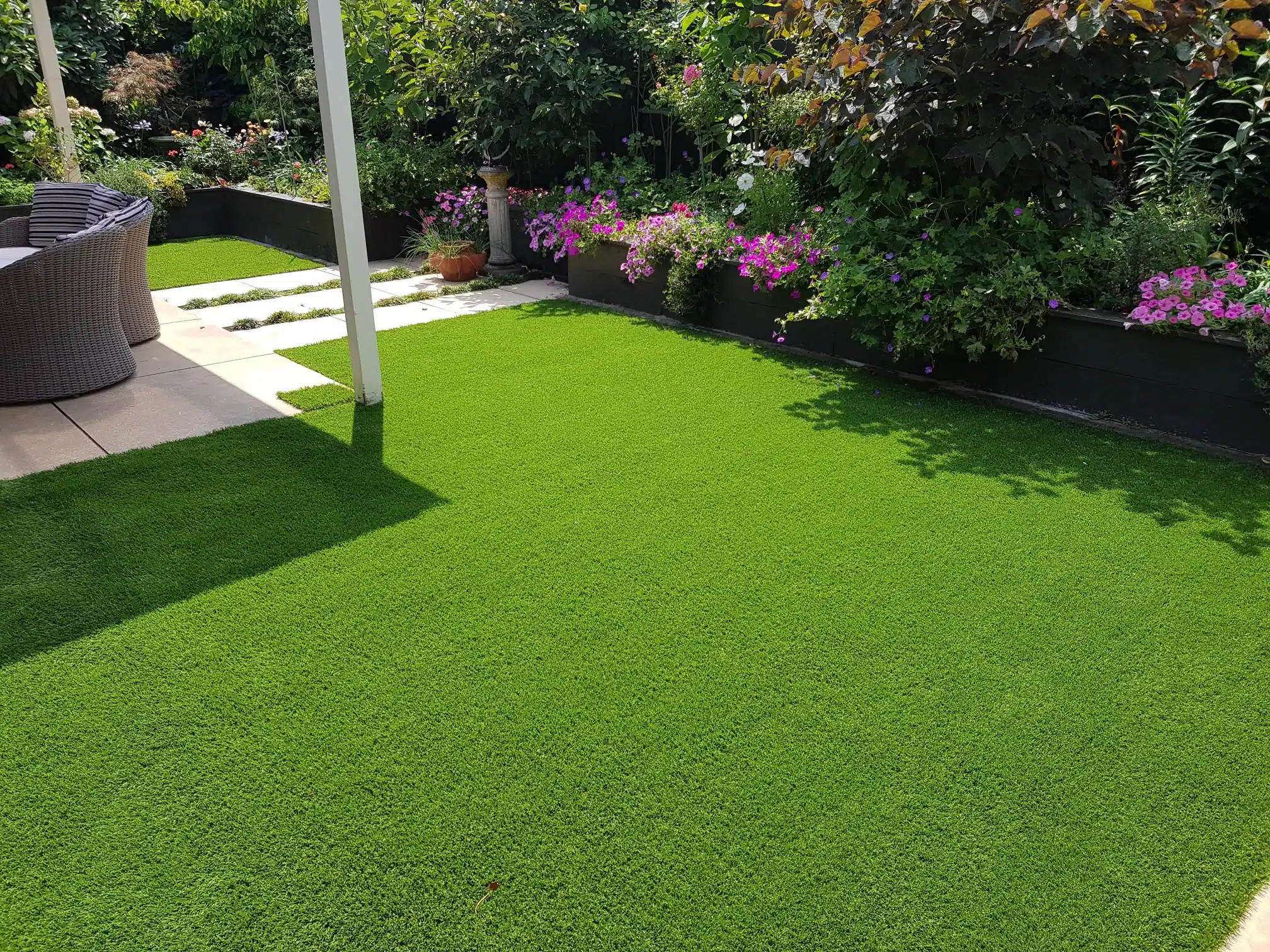 20180127_114849 Outdoor seating area surrounded by artificial lawn and flower border.