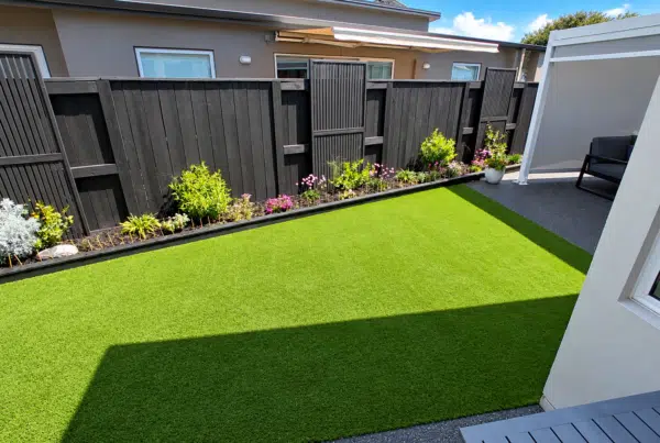 Meadow FlowTech artificial grass installed in a residential Tauranga backyard with garden beds